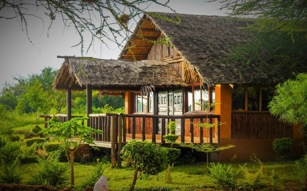 a small house with a thatched roof at Teen Ranch Kenya in Amboseli