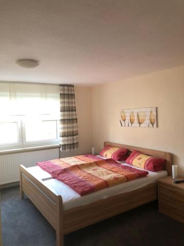 a bedroom with a bed and a window at Gästehaus Goldhorn in Rödental