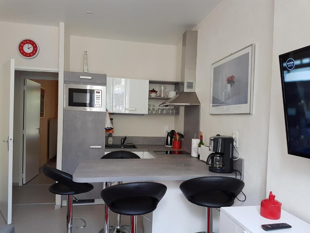 a kitchen with a counter and stools in it at Chalet Bruyère in Cauterets
