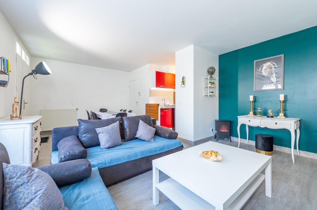 a living room with a blue couch and a table at Family Travel Paris 3 in Bussy-Saint-Georges