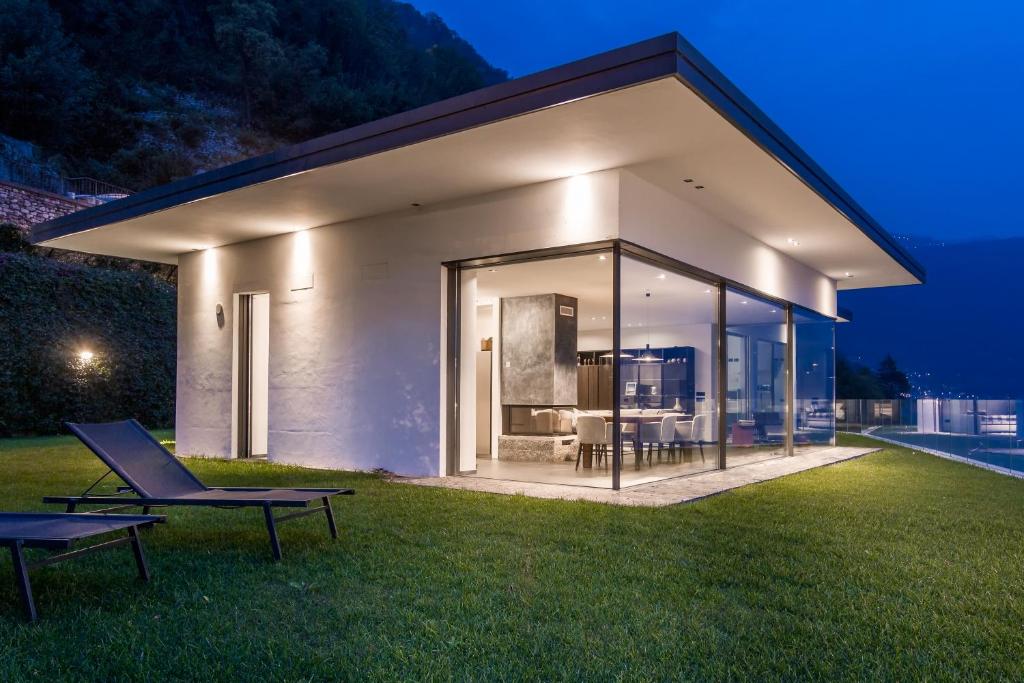 a house with a view of the backyard at night at Marvelous Lake Destination eco-friendly villa in Brienno