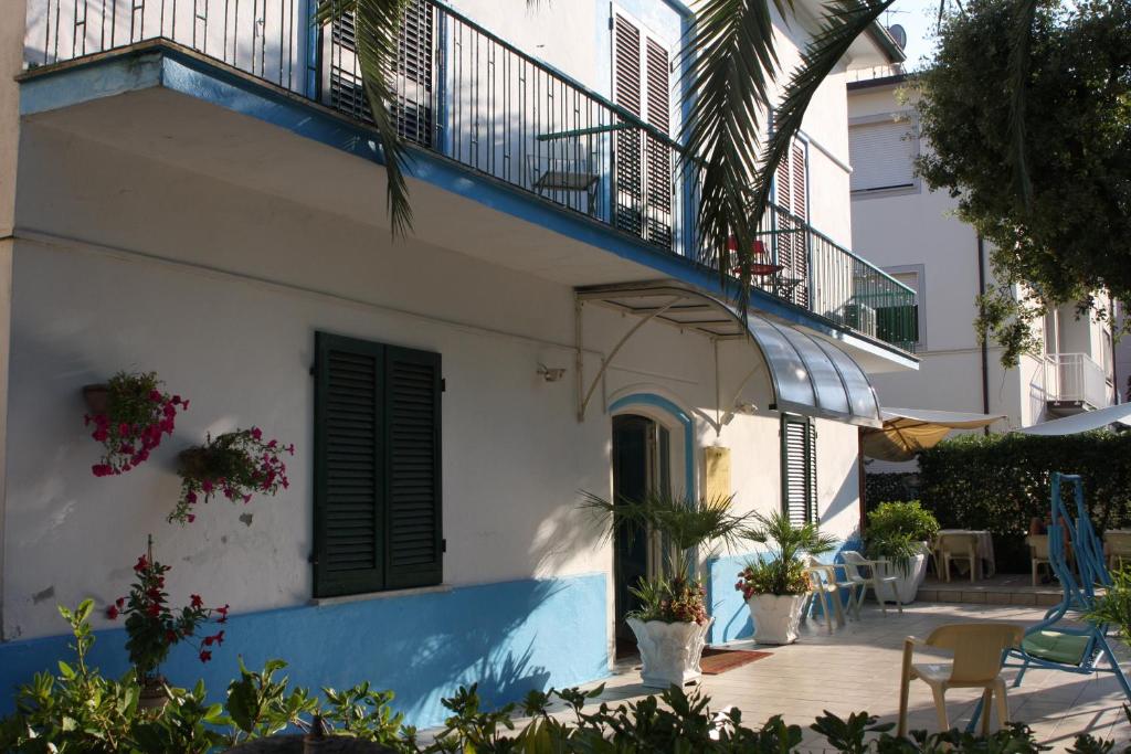 a white building with a blue and white balcony at Hotel Ornella in Lido di Camaiore