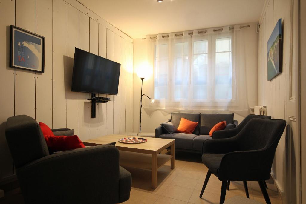 sala de estar con sofá, sillas y TV en Au bonheur d'Etretat, en Étretat