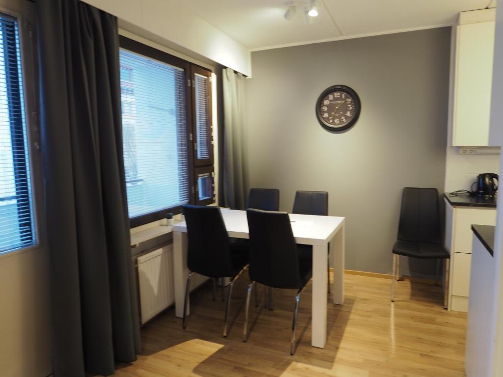 a kitchen and dining room with a table and chairs at Apartment Oulu station II in Oulu