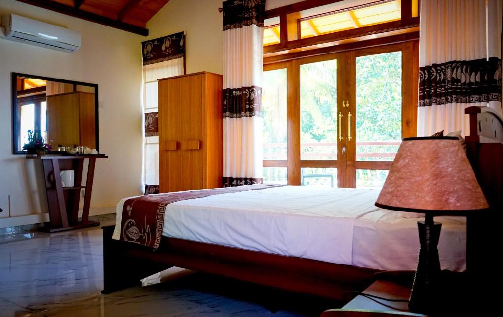 a bedroom with a bed and a large window at SUNSET HILLS in Kandy