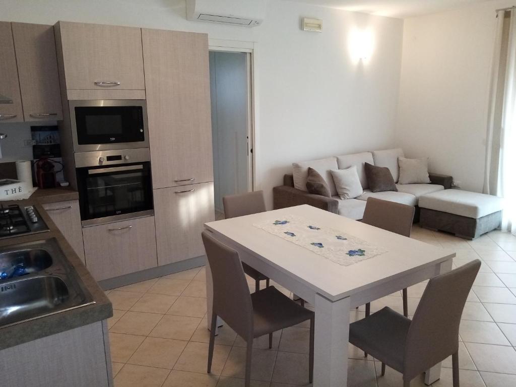 a kitchen and living room with a white table and chairs at Terrapiana Home in Rosà