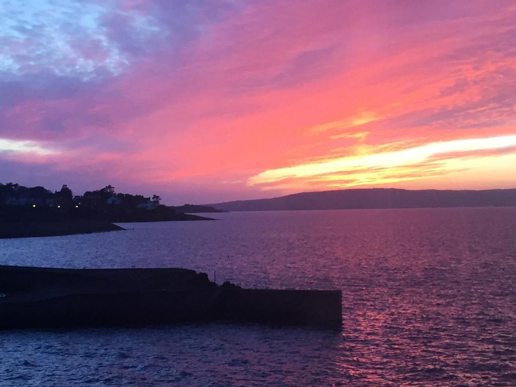 um pôr-do-sol sobre uma grande massa de água em Perfect getaway, seafront home em Bangor