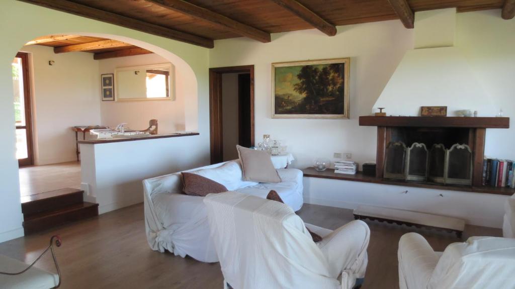 uma sala de estar com mobiliário branco e uma lareira em B&B Casa Soresina em Offagna