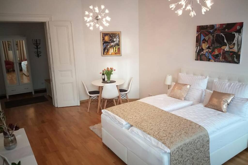 1 dormitorio con 1 cama y 1 mesa con sillas en Apartments MUSIKVIERTEL en Leipzig