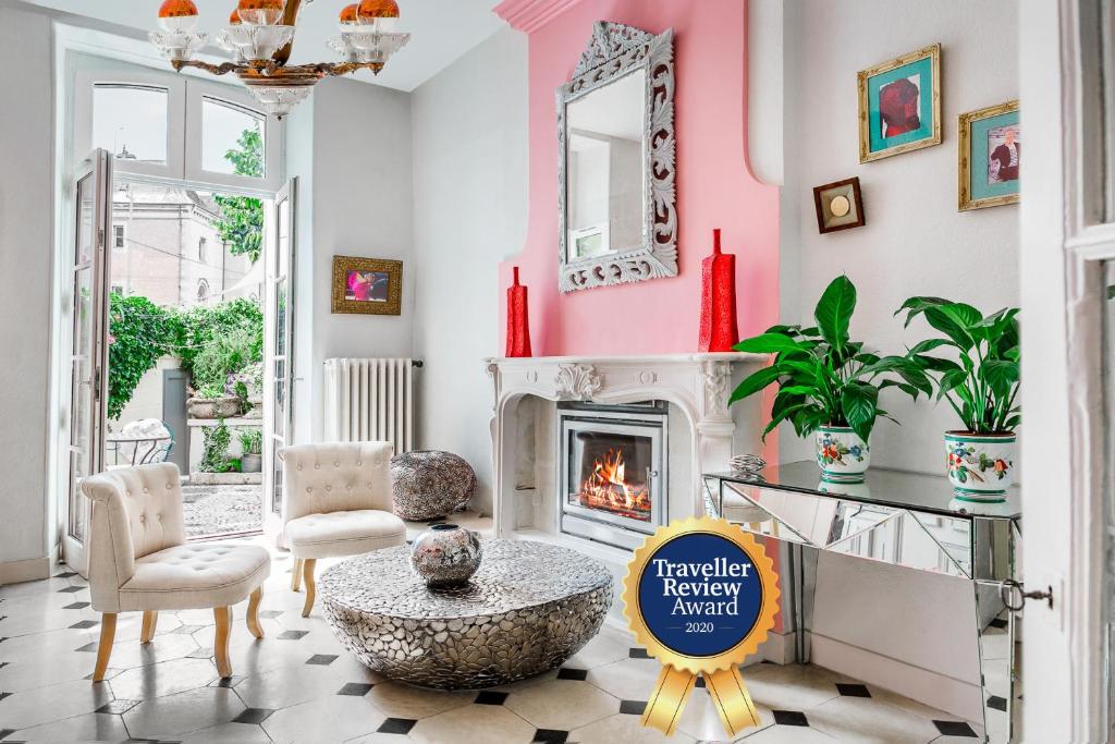 uma sala de estar com lareira e paredes cor-de-rosa em La Maison Charmante em Châtellerault
