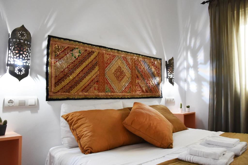 een slaapkamer met een bed met een kleed aan de muur bij Puerta Real Apartamentos in Sevilla