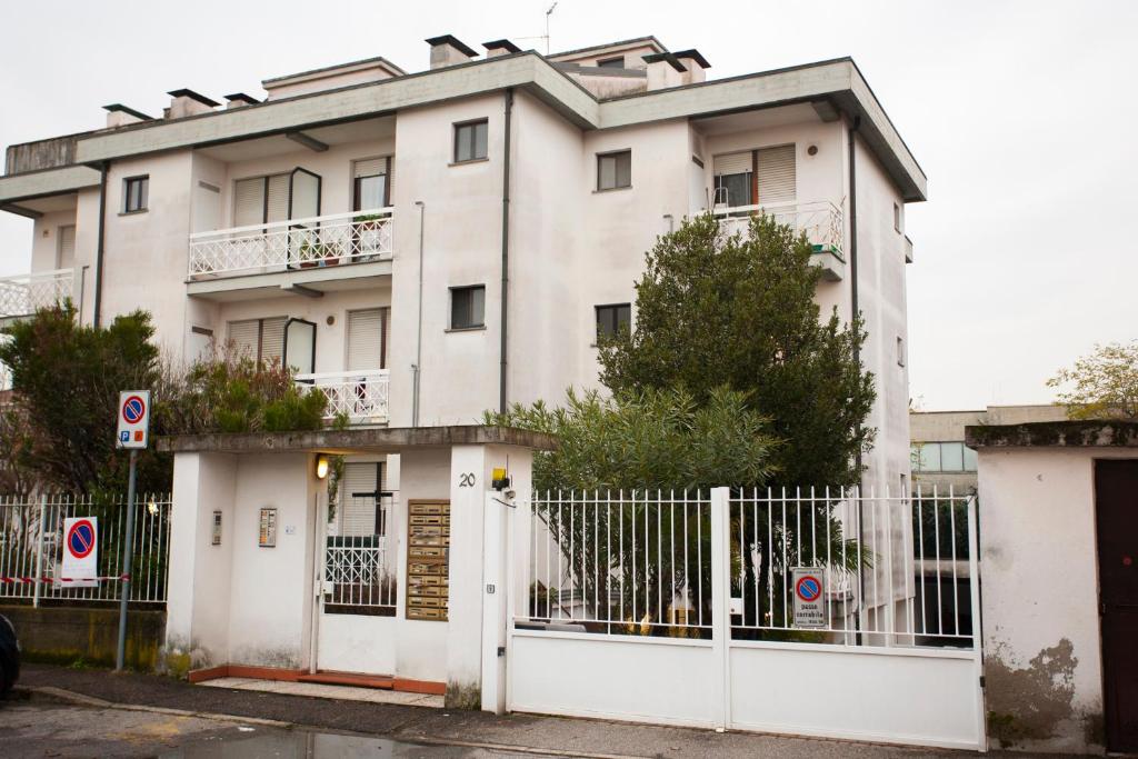Biały budynek z bramą i płotem w obiekcie BNBOOK-Passirana Studio w mieście Rho