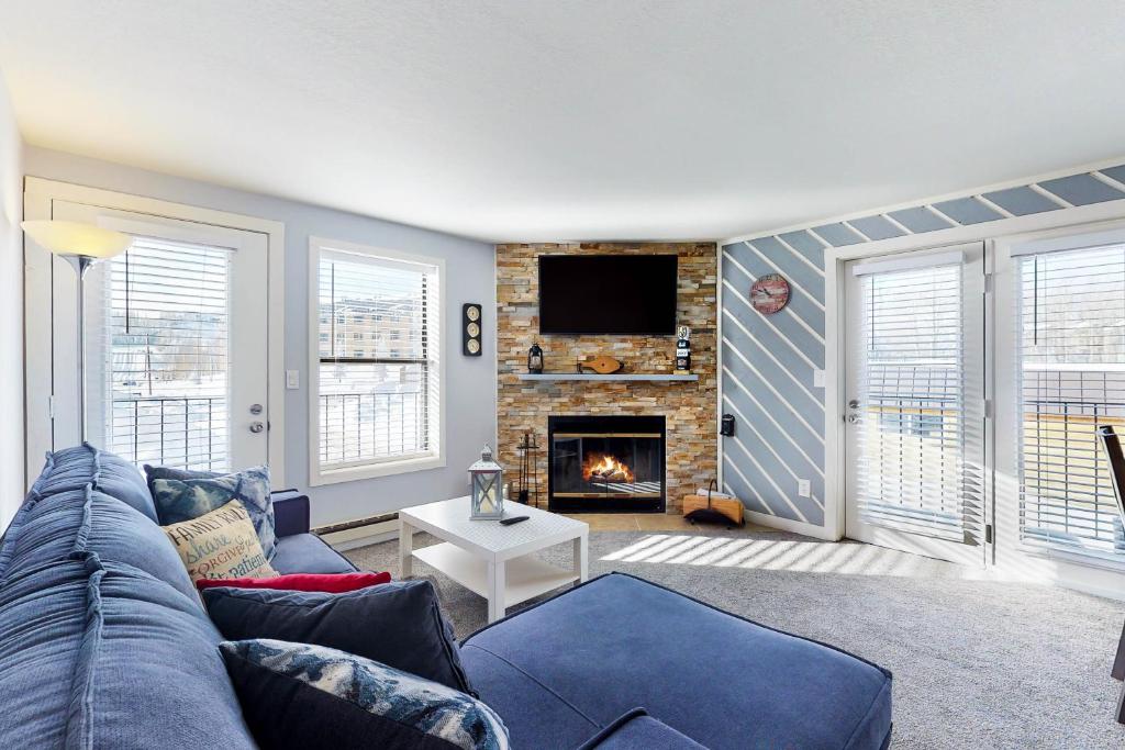 a living room with a blue couch and a fireplace at Timberbrook #215A in Brian Head