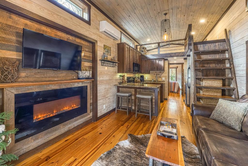 una sala de estar con chimenea en una casa pequeña en Smoky Mountain Tiny Home, en Pigeon Forge