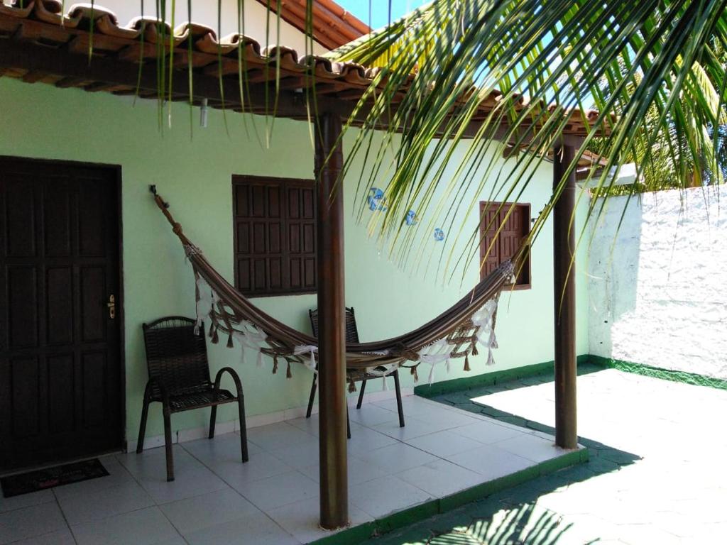 a porch with a hammock and a chair on a house at KitnetPrado in Prado