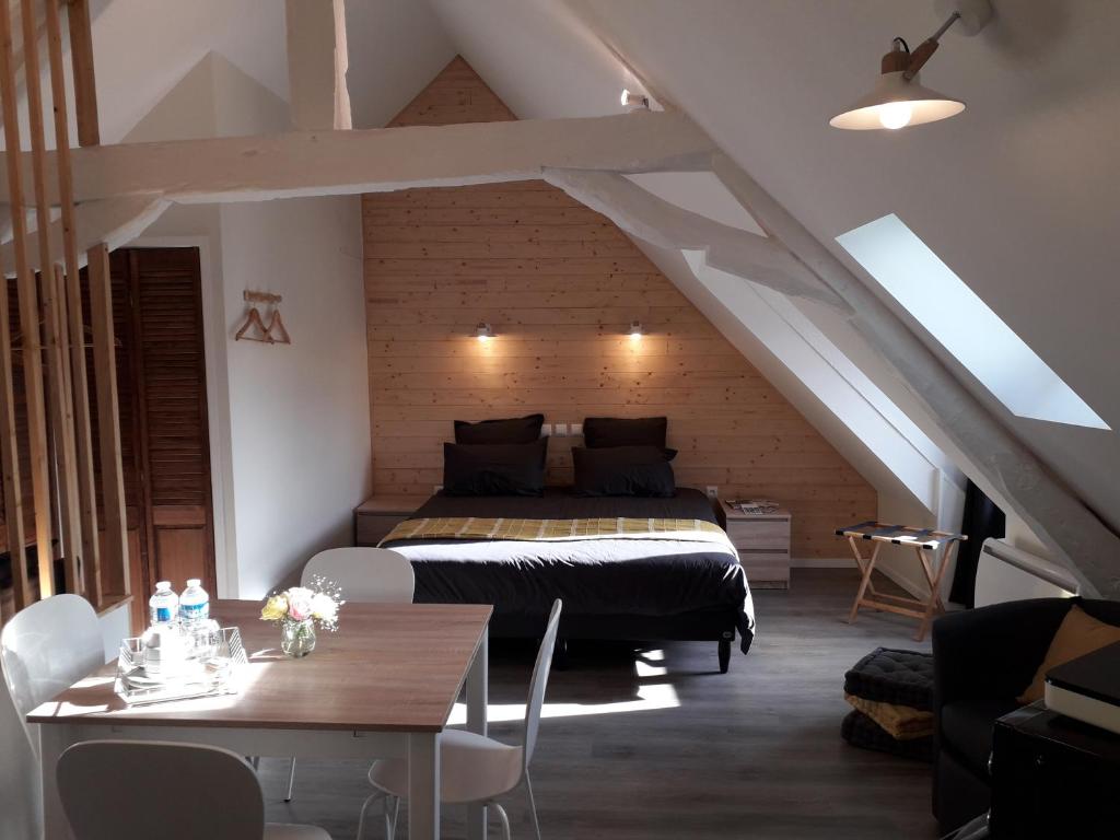 - une chambre avec un lit et une table dans l'établissement CHARMES EN VILLE Le Charme Authentique, à Montluçon