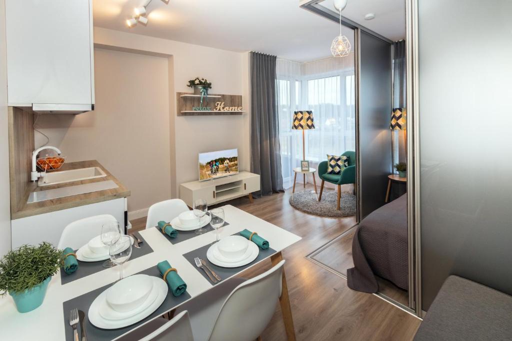uma cozinha e sala de estar com mesa e cadeiras em Relax apartments near Egle em Druskininkai