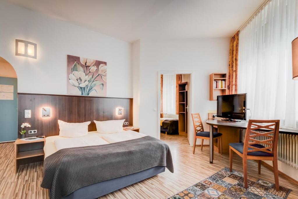 una camera d'albergo con letto e scrivania di Gästehaus Centro a Costanza