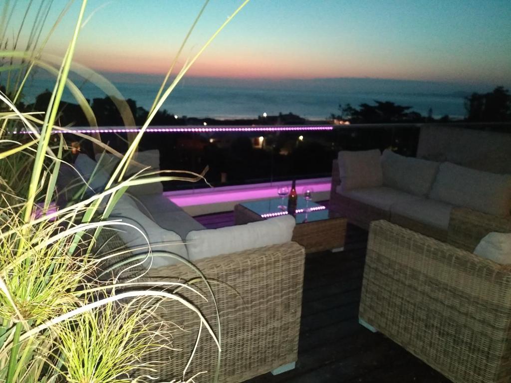 a living room with couches and a pool at night at Rinconada del Mar in Punta del Este