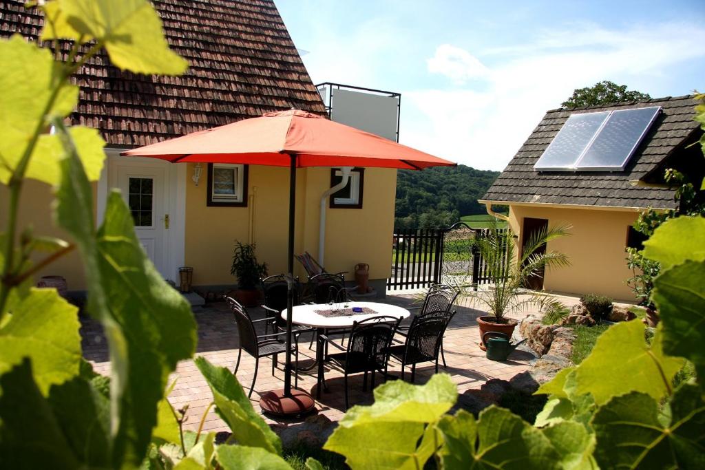patio ze stołem, krzesłami i parasolem w obiekcie Ferienhaus am Meisslberg w mieście Bad Gleichenberg