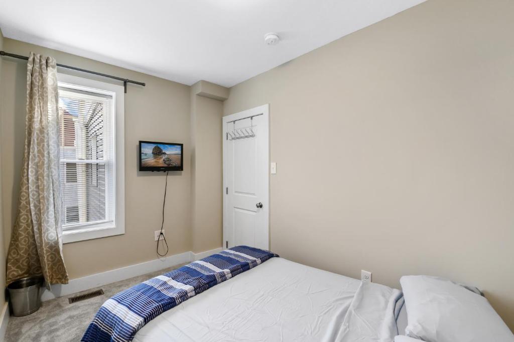 a bedroom with a white bed and a window at Luxury Rooms near Temple U, Drexel, UPenn, and the MET in Philadelphia