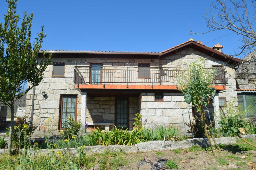 een stenen huis met een balkon erboven bij Carneiro Country Houses Casa do Avô in Carneiro