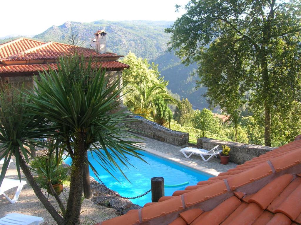 um resort com piscina e montanhas ao fundo em Casas das Guimbras no Gerês