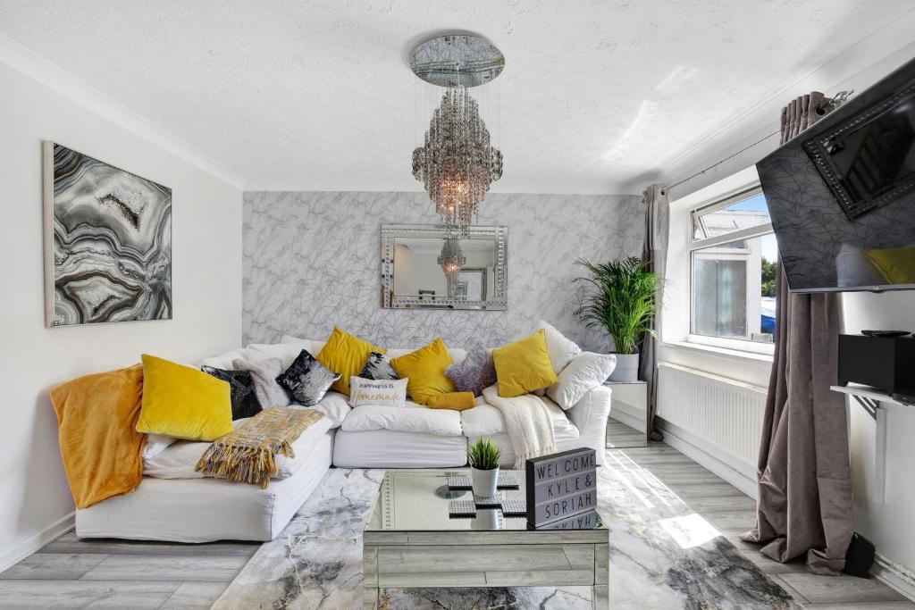 sala de estar con sofá blanco y almohadas amarillas en The Spacious Gem House Kent with Parking, en Gillingham