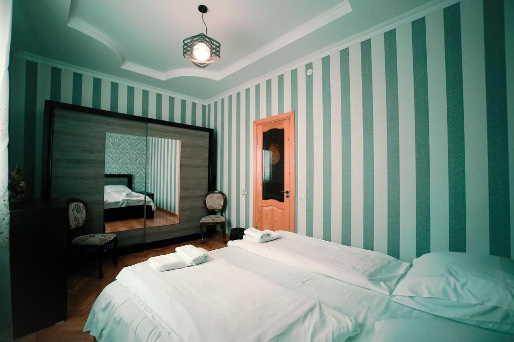 a bedroom with a large bed and a mirror at Apartment OLD KUTAISI in Kutaisi