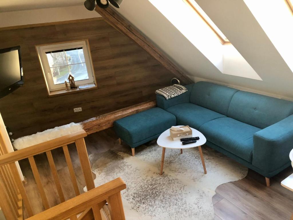 a living room with a blue couch and a table at Apartmán U Kapličky in Hluboká nad Vltavou