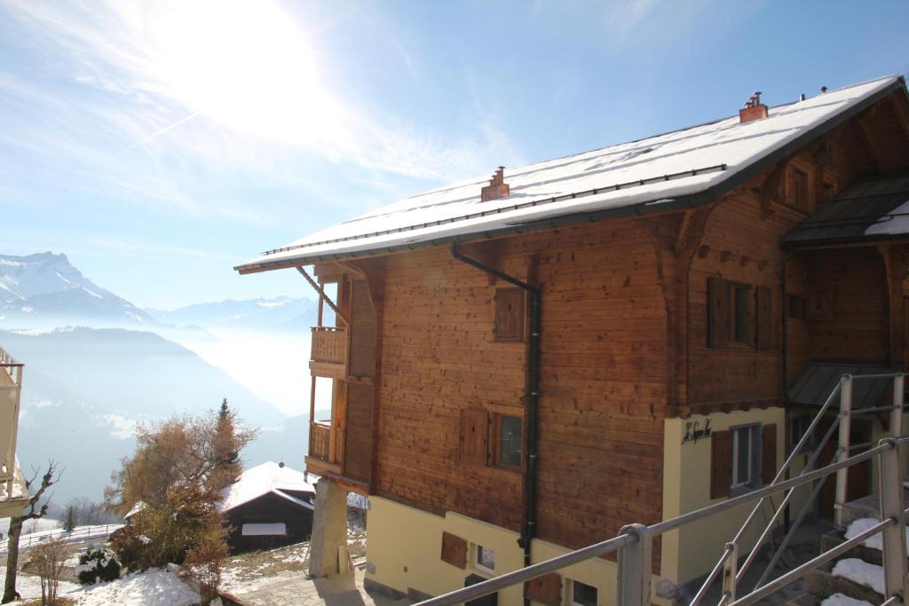 une maison avec un toit enneigé sur une montagne dans l'établissement Sapin Vert, à Leysin