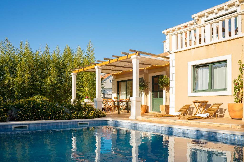 ein Haus mit einem Pool vor einem Haus in der Unterkunft Villa Maha - Pool and Jacuzzi, included Breakfast in Korčula