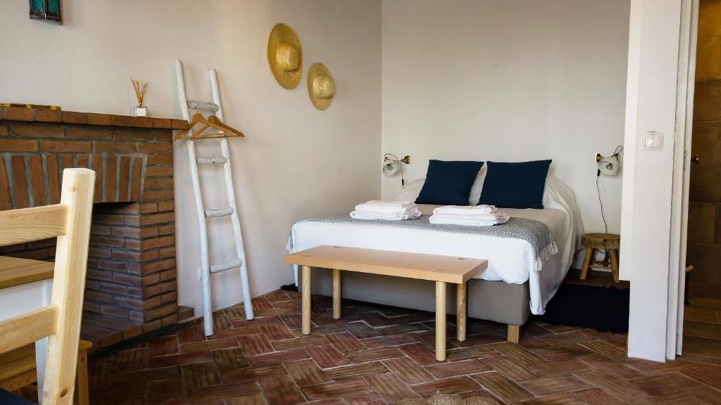 a small bedroom with a bed and a table at Casas de Mértola 32 in Mértola