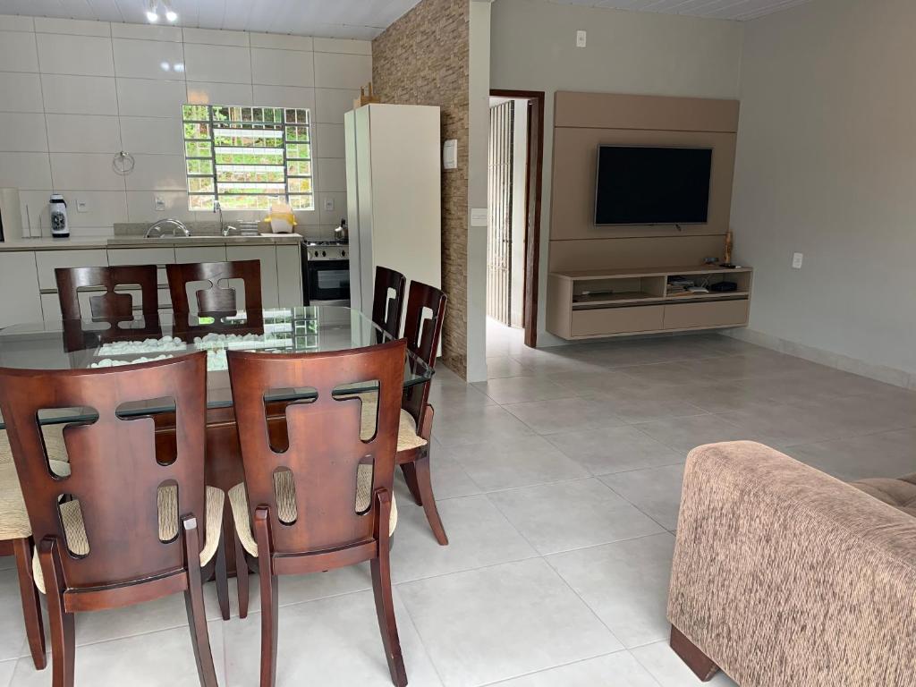 a kitchen and living room with a table and chairs at Casa Guarda do Embaú in Guarda do Embaú