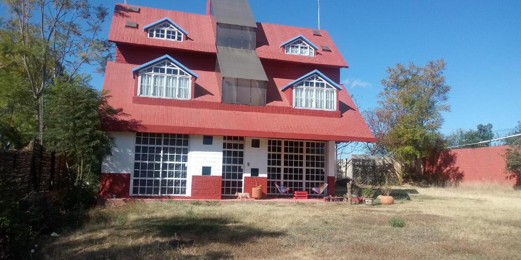 a house with a red roof on top of a yard at Casa de campo en Oaxaca in San Pablo Etla