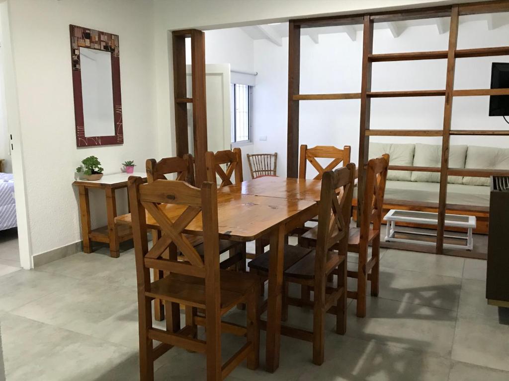 comedor con mesa de madera y sillas en el Departamento Jardín - 1 en Villa Gesell