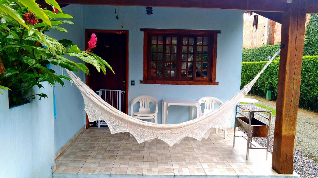 een veranda met een hangmat voor een huis bij casa em condomínio com piscina in Maresias