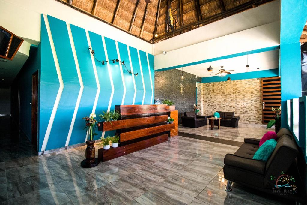 een woonkamer met een bank en een blauwe muur bij isel magic hotel in Bacalar