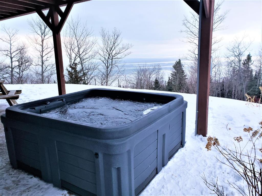 un bain à remous installé sous un kiosque dans la neige dans l'établissement La plus belle vue du secteur - La Forteresse, à Petite-Rivière-Saint-François