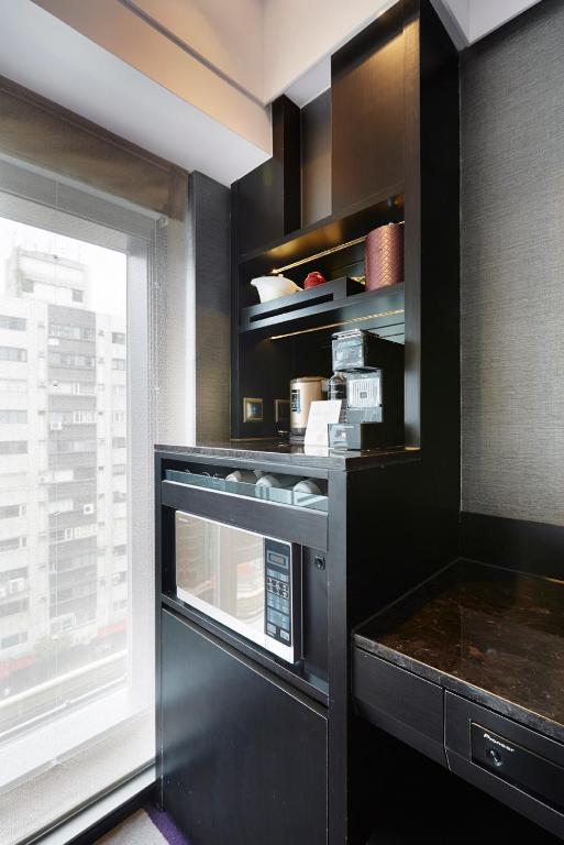 a kitchen with a microwave and a window at The Tango Hotel Taipei FuHsing in Taipei