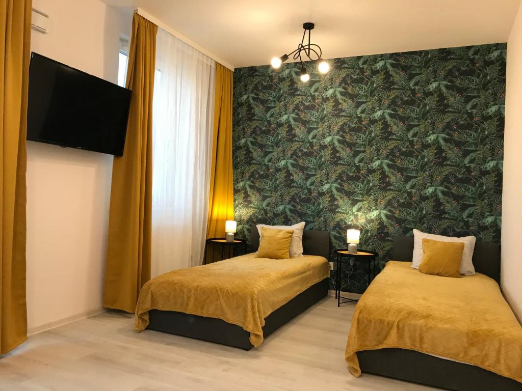 2 camas en una habitación con un mural en la pared en Apartamenty Brzeska 10, en Varsovia