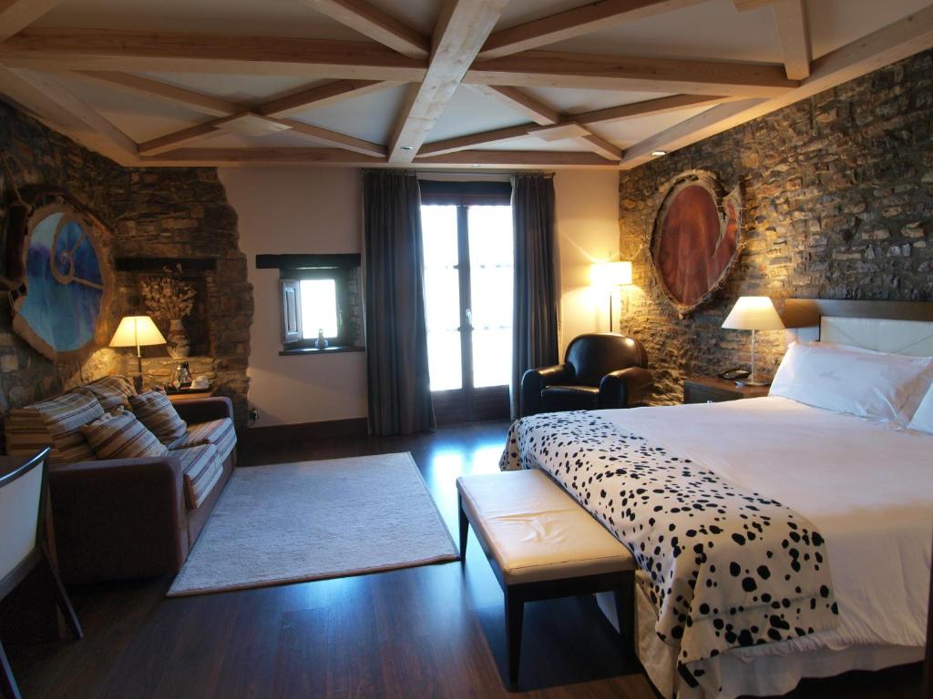 una camera d'albergo con letto e soggiorno di Los Siete Reyes ad Aínsa