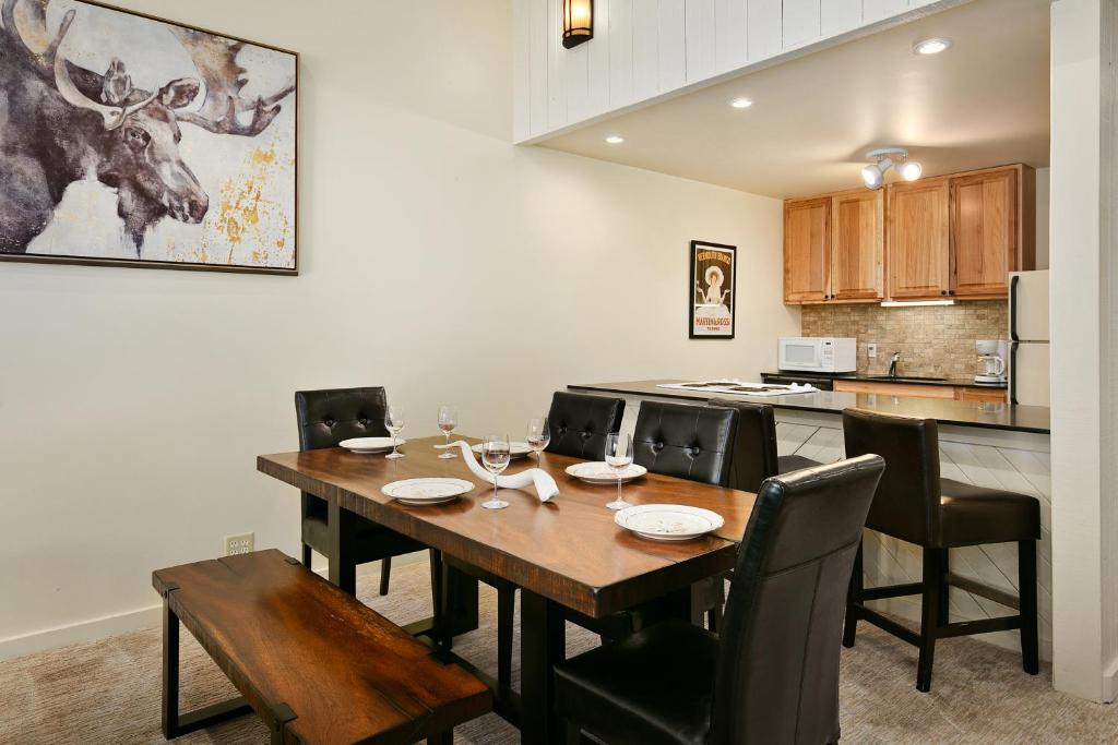 a dining room with a table and chairs and a kitchen at Three Kings by White Pines in Park City