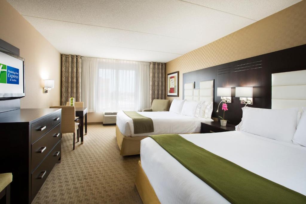a hotel room with two beds and a flat screen tv at Holiday Inn Express & Suites Ottawa West - Nepean by IHG in Ottawa