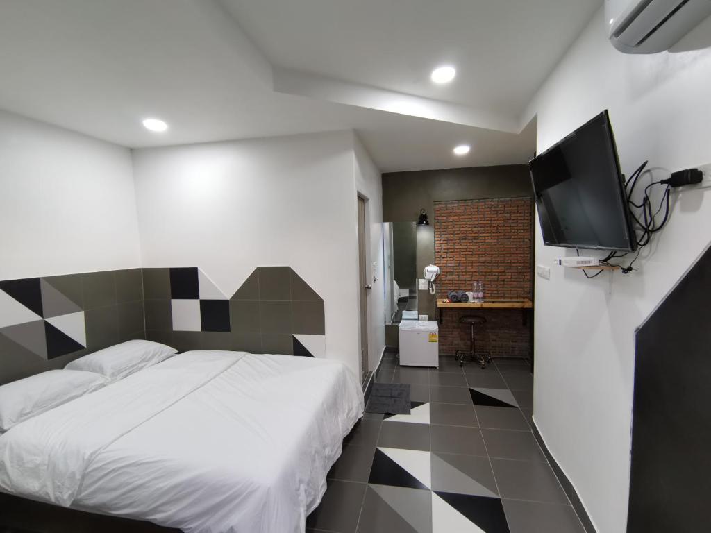 a bedroom with a bed and a flat screen tv at Hoft Hotel in Bangkok