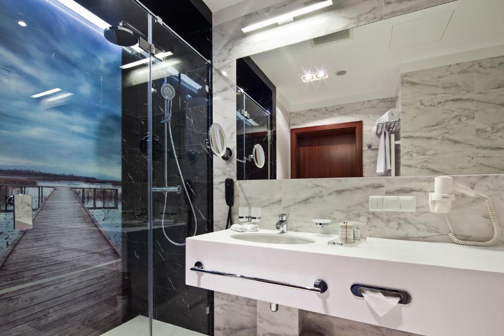 a bathroom with a sink and a shower at Hotel Mikołajki Leisure &amp; SPA in Mikołajki