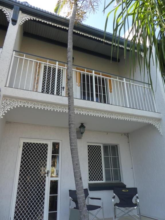 una casa blanca con 2 sillas y una palmera en Townsville Terrace, en Townsville