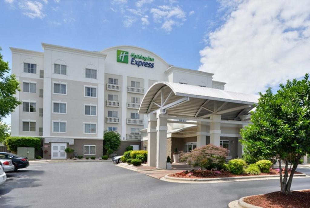 Holiday Inn Express Hotel & Suites Mooresville - Lake Norman, an IHG Hotel في موورسفيل: فندق امامه موقف سيارات