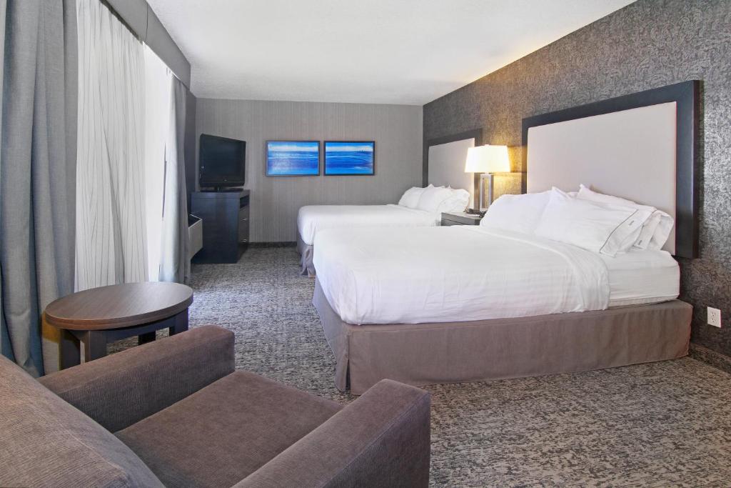 a hotel room with two beds and a couch at Holiday Inn Express and Suites Calgary by IHG in Calgary