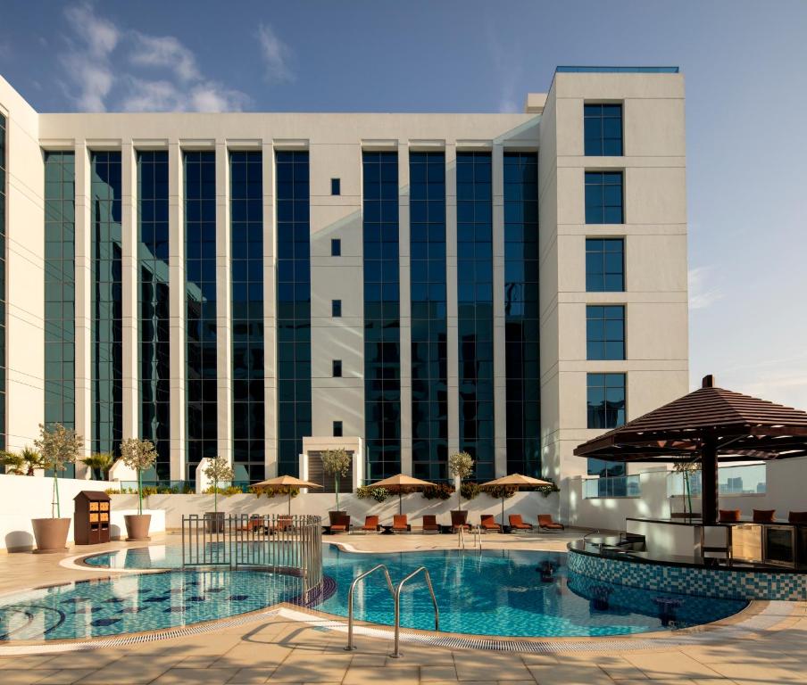 een hotel met zwembad en gebouw bij Hyatt Place Dubai Jumeirah in Dubai
